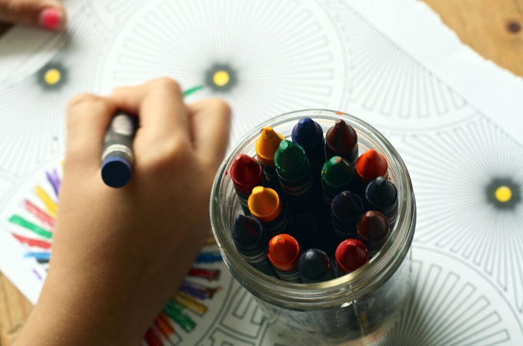 Child quietly coloring at a table with crayons